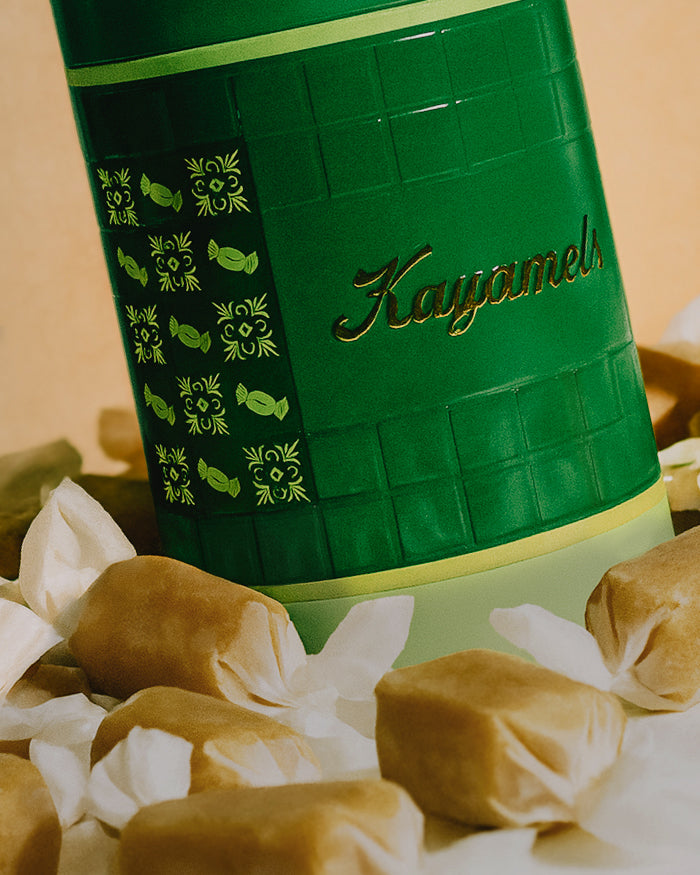Green container of Kayamel candies with caramels around it.